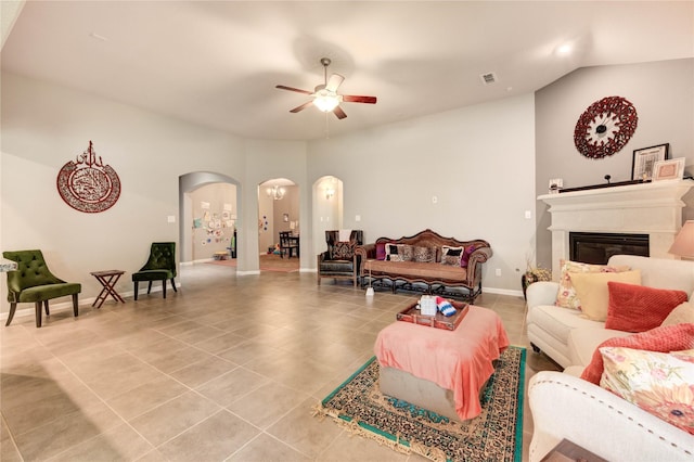 6119 Cresting Knolls Cir, Richmond, TX 77407 - living area featuring arched walkways, light tile patterned flooring, ceiling fan, vaulted ceiling, and a glass covered fireplace