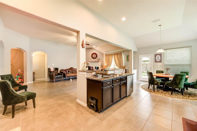 6119 Cresting Knolls Cir, Richmond, TX 77407 - kitchen featuring open floor plan, arched walkways, light stone counters, light tile patterned floors, and hanging light fixtures