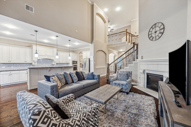 6815 Cottonwood Crest Ln, Katy, TX 77493 - living area with ornamental molding, a towering ceiling, dark wood-style floors, stairway, and arched walkways