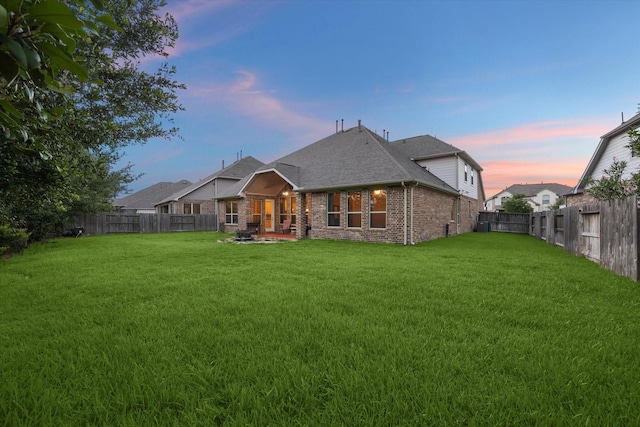 6815 Cottonwood Crest Ln, Katy, TX 77493 - back of property featuring brick siding, roof with shingles, and a patio