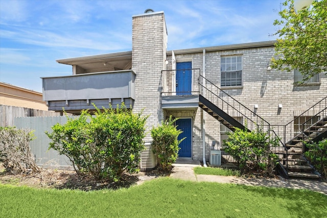 9700 Leawood Blvd Unit 216, Houston, TX 77099 - back of house featuring stairs, a chimney, brick siding, and a balcony