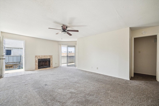 9700 Leawood Blvd Unit 216, Houston, TX 77099 - unfurnished living room featuring ceiling fan, carpet, a high end fireplace, baseboards, and a textured ceiling