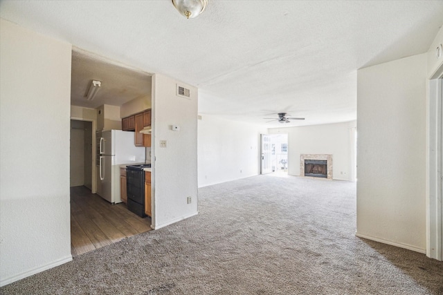9700 Leawood Blvd Unit 216, Houston, TX 77099 - unfurnished living room with carpet flooring, ceiling fan, a high end fireplace, and baseboards