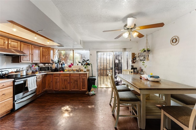 7322 Crownwest St Unit 7322, Houston, TX 77072 - kitchen with under cabinet range hood, appliances with stainless steel finishes, brown cabinetry, a ceiling fan, and a textured ceiling