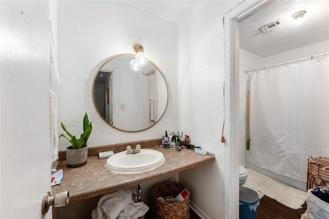 7322 Crownwest St Unit 7322, Houston, TX 77072 - full bath featuring toilet, vanity, a shower with curtain, wood finished floors, and a textured ceiling
