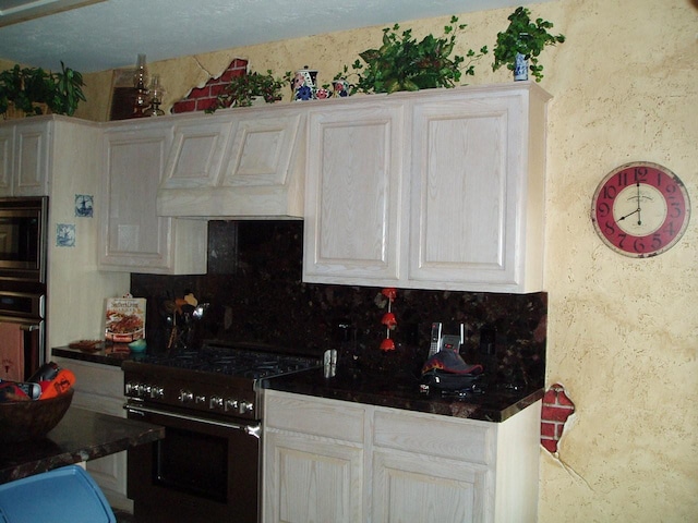 15014 Redbud Leaf Ln, Cypress, TX 77433 - kitchen featuring range with gas cooktop, stainless steel microwave, oven, a textured wall, and premium range hood