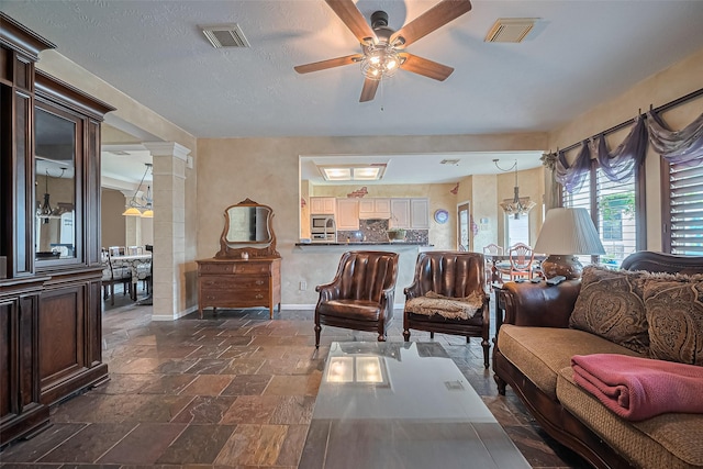 15014 Redbud Leaf Ln, Cypress, TX 77433 - living area featuring a ceiling fan, stone tile flooring, and ornate columns