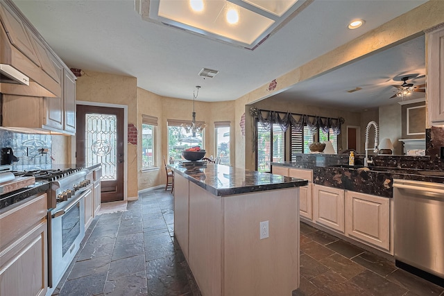 15014 Redbud Leaf Ln, Cypress, TX 77433 - kitchen with stainless steel appliances, stone tile floors, plenty of natural light, a center island, and recessed lighting