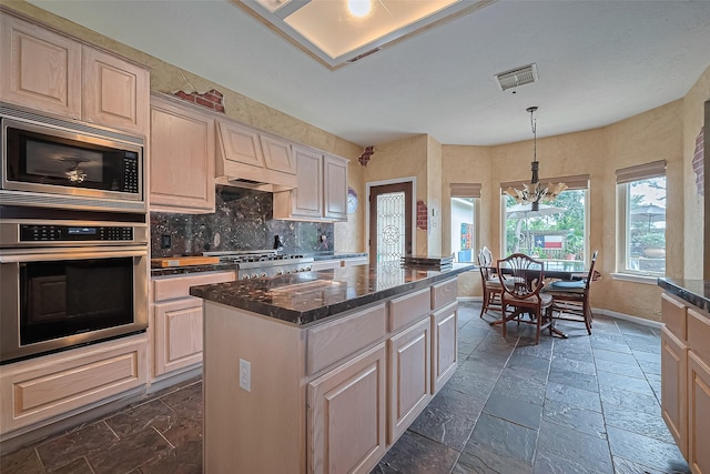 15014 Redbud Leaf Ln, Cypress, TX 77433 - kitchen with appliances with stainless steel finishes, a kitchen island, decorative backsplash, decorative light fixtures, and dark stone counters