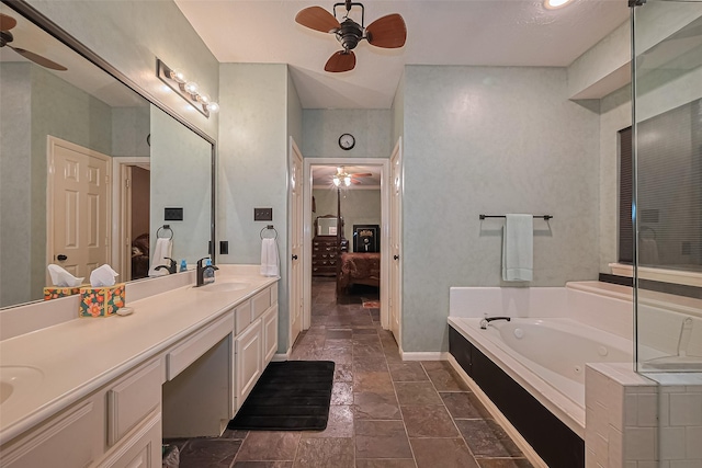15014 Redbud Leaf Ln, Cypress, TX 77433 - full bathroom featuring ceiling fan, connected bathroom, a tub with jets, double vanity, and stone tile floors