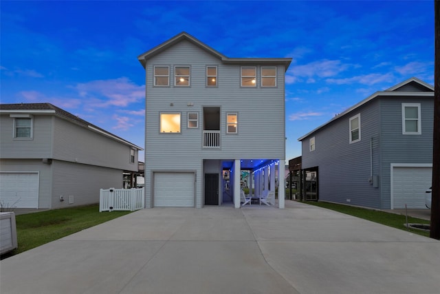 16710 Tahiti Way, Jamaica Beach, TX 77554 - rear view of house featuring an attached garage, driveway, and stairway