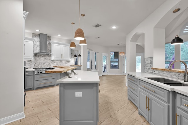 28315 Hollow Springs Ln, Spring, TX 77386 - kitchen featuring gray cabinets, wall chimney range hood, a sink, a kitchen island, and backsplash