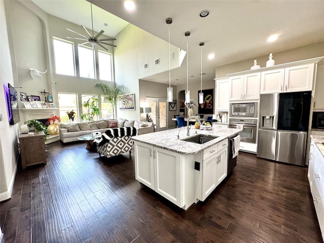 9723 Reston Ranch Ct, Cypress, TX 77433 - kitchen featuring appliances with stainless steel finishes, a sink, a ceiling fan, open floor plan, and white cabinets