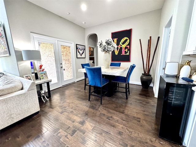 9723 Reston Ranch Ct, Cypress, TX 77433 - dining space featuring arched walkways, french doors, dark wood finished floors, wine cooler, and baseboards