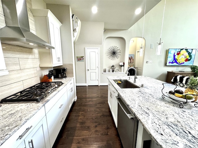 9723 Reston Ranch Ct, Cypress, TX 77433 - kitchen with wall chimney range hood, appliances with stainless steel finishes, a sink, light stone countertops, and decorative backsplash