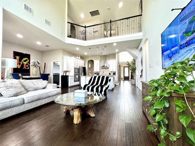 9723 Reston Ranch Ct, Cypress, TX 77433 - living area featuring a high ceiling, dark wood-style flooring, and arched walkways
