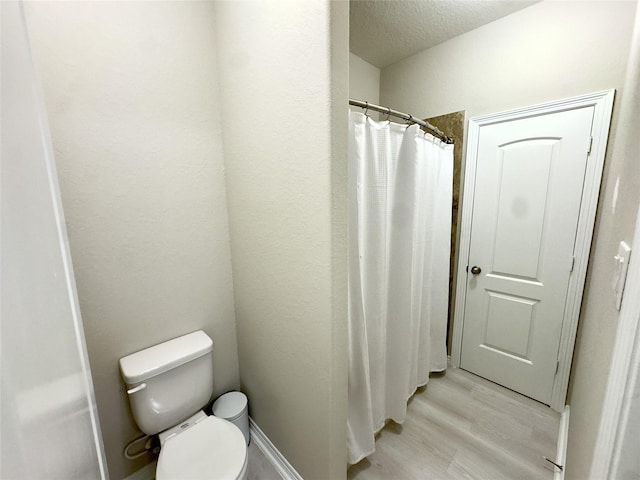 9723 Reston Ranch Ct, Cypress, TX 77433 - full bath with toilet, a textured ceiling, wood finished floors, and a shower with curtain