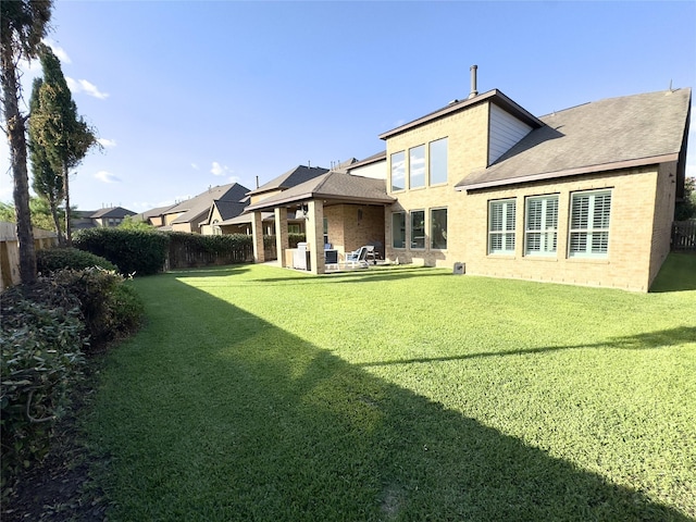 9723 Reston Ranch Ct, Cypress, TX 77433 - rear view of property featuring roof with shingles, a patio area, and brick siding