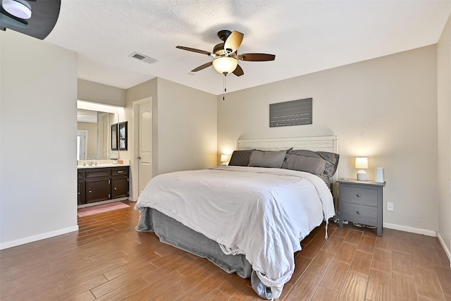 17202 Heritage Bay Dr, Webster, TX 77598 - bedroom with baseboards, wood finished floors, connected bathroom, and ceiling fan