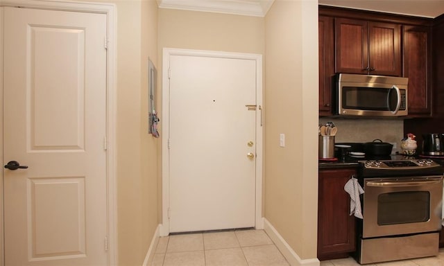 2203 Dorrington St Unit 208, Houston, TX 77030 - kitchen featuring stainless steel appliances, ornamental molding, baseboards, light tile patterned floors, and dark countertops