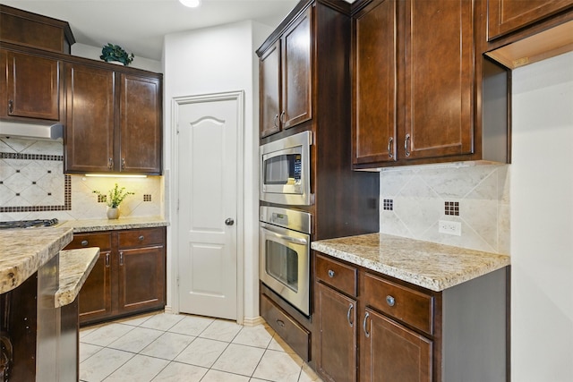19014 Ridge Cove Ln, Cypress, TX 77433 - kitchen featuring stainless steel appliances, light tile patterned floors, tasteful backsplash, dark brown cabinetry, and recessed lighting