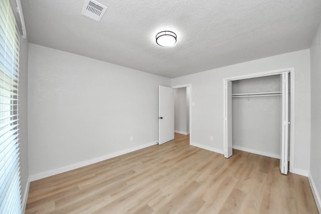 4439 Kacee Dr, Houston, TX 77084 - unfurnished bedroom with light wood-style flooring, a textured ceiling, and a closet