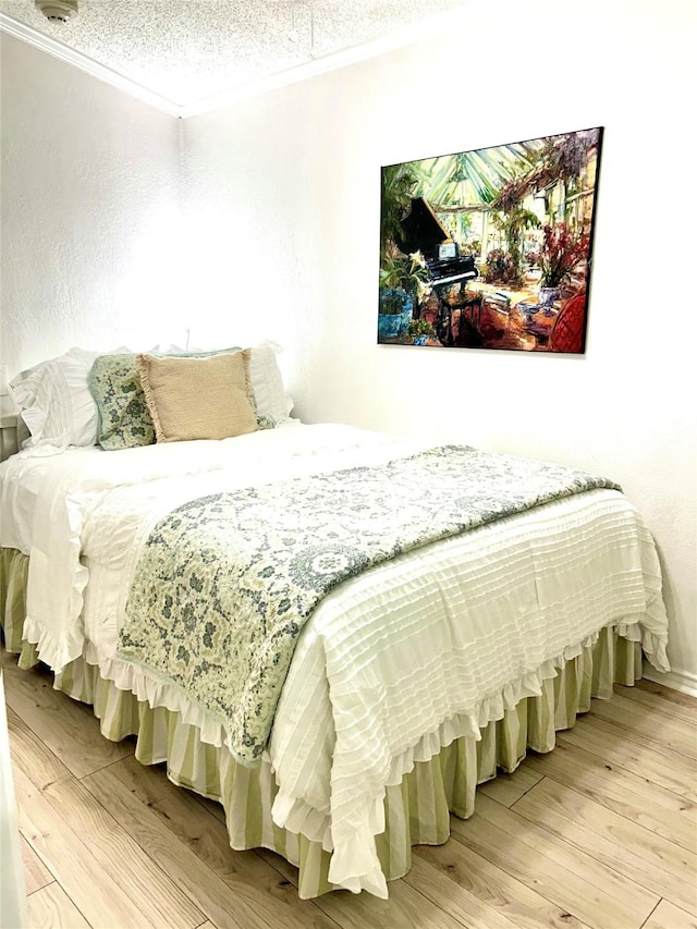 6102 Seawall Blvd S Unit 229, Galveston, TX 77551 - bedroom featuring crown molding, light wood-type flooring, and a textured ceiling