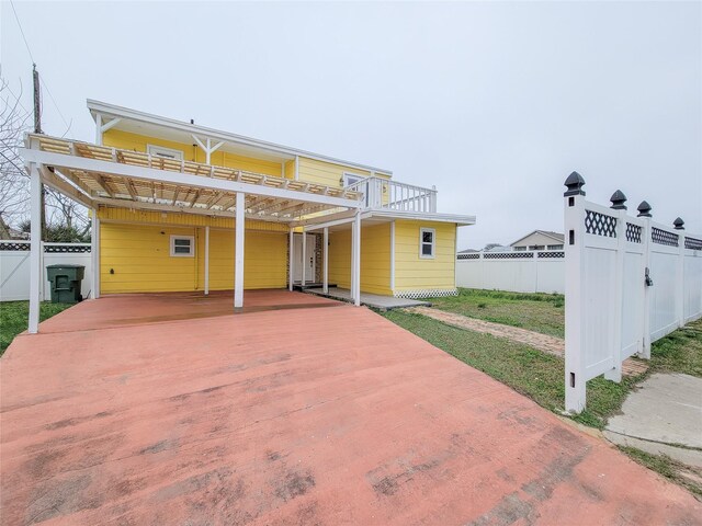 5703 Fraser Ave, Galveston, TX 77551 - view of front facade with a deck, driveway, and an attached carport