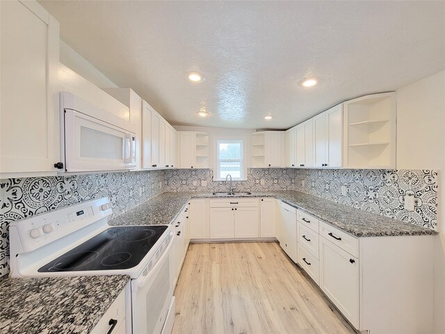5703 Fraser Ave, Galveston, TX 77551 - kitchen with open shelves, white appliances, light wood finished floors, a sink, and dark stone countertops