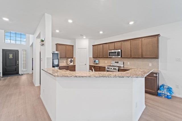 5107 Twin Summit Dr, Rosenberg, TX 77469 - kitchen featuring stainless steel microwave, gas stove, light wood finished floors, baseboards, and recessed lighting