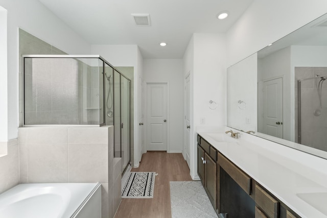 5107 Twin Summit Dr, Rosenberg, TX 77469 - bathroom with a stall shower, double vanity, wood finished floors, a bath, and recessed lighting