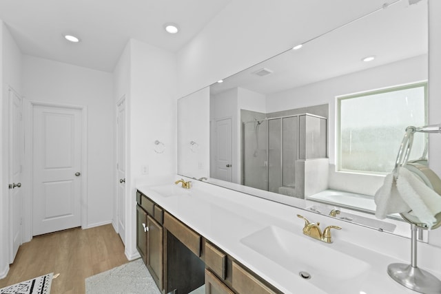 5107 Twin Summit Dr, Rosenberg, TX 77469 - full bath with a stall shower, a bath, wood finished floors, double vanity, and recessed lighting