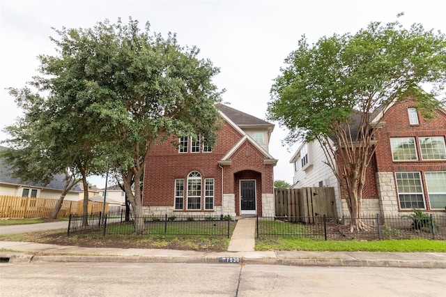 7530 Autumn Sun Dr, Houston, TX 77083 - traditional-style house featuring stone siding, brick siding, and a fenced front yard