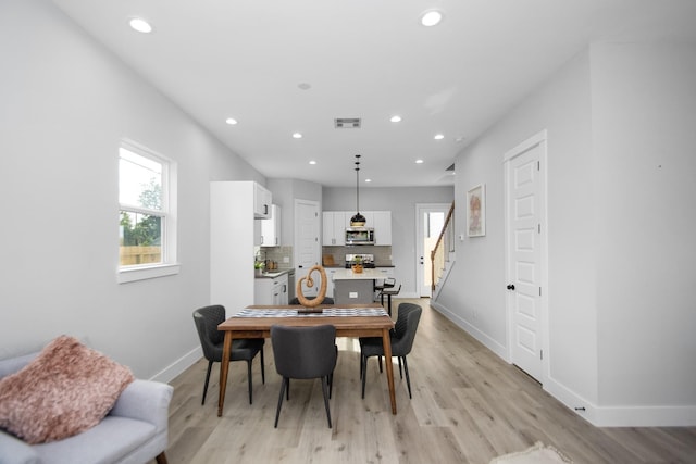 2105 Sam Wilson St Unit A, Houston, TX 77020 - dining area featuring baseboards, stairway, recessed lighting, and light wood finished floors