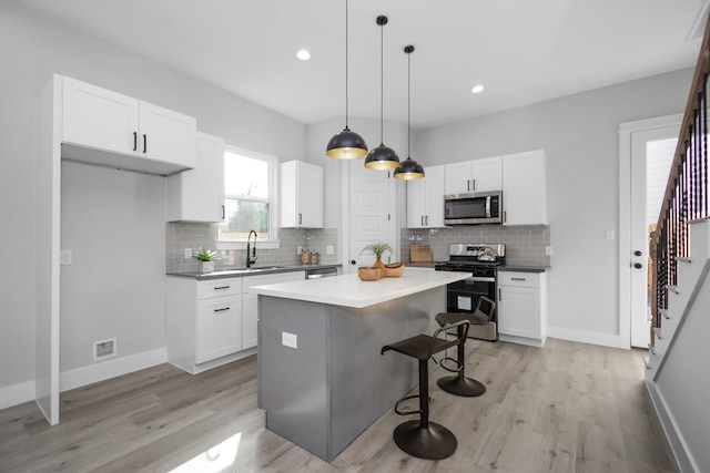 2105 Sam Wilson St Unit A, Houston, TX 77020 - kitchen featuring stainless steel appliances, a kitchen breakfast bar, backsplash, white cabinetry, and recessed lighting