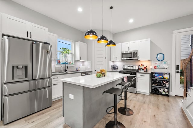 2105 Sam Wilson St Unit A, Houston, TX 77020 - kitchen featuring stainless steel appliances, white cabinetry, a sink, a kitchen bar, and recessed lighting