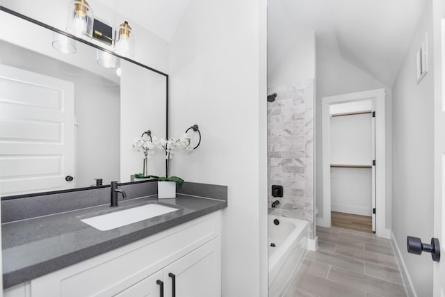2105 Sam Wilson St Unit A, Houston, TX 77020 - bathroom with vanity, washtub / shower combination, lofted ceiling, baseboards, and wood finished floors