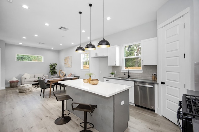 2105 Sam Wilson St Unit A, Houston, TX 77020 - kitchen featuring stainless steel dishwasher, gas stove, a sink, a kitchen breakfast bar, and plenty of natural light