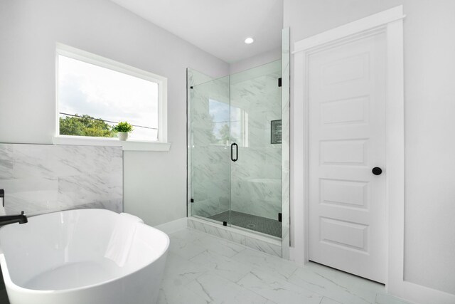 2105 Sam Wilson St Unit A, Houston, TX 77020 - full bath featuring a soaking tub, a marble finish shower, marble look tile flooring, recessed lighting, and baseboards