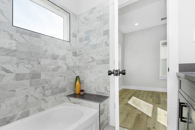 2105 Sam Wilson St Unit A, Houston, TX 77020 - full bath featuring a tub to relax in, wood finished floors, vanity, baseboards, and recessed lighting