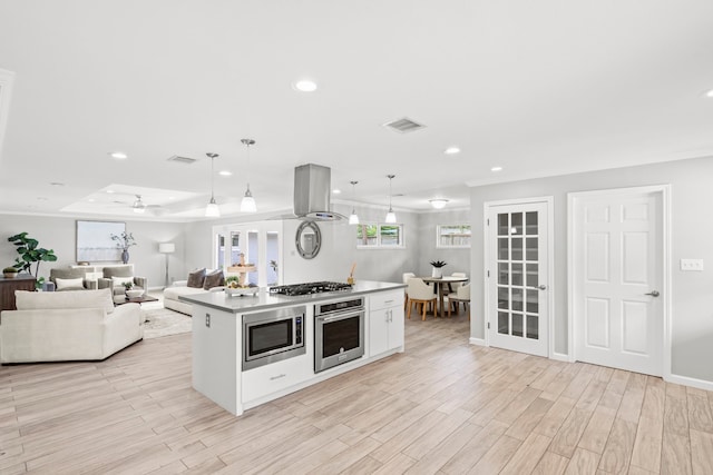 3619 N Braeswood Blvd, Houston, TX 77025 - kitchen with stainless steel appliances, island exhaust hood, recessed lighting, light wood finished floors, and hanging light fixtures