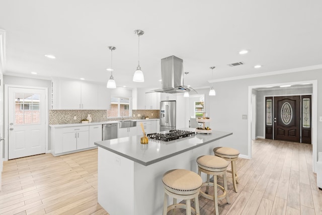 3619 N Braeswood Blvd, Houston, TX 77025 - kitchen with stainless steel appliances, island range hood, healthy amount of natural light, tasteful backsplash, and ornamental molding