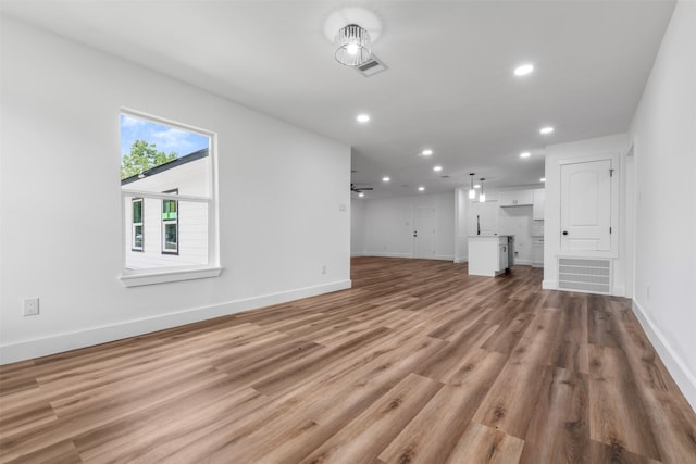 6155 Ridgeway Dr, Houston, TX 77033 - unfurnished living room with recessed lighting and light wood-style floors