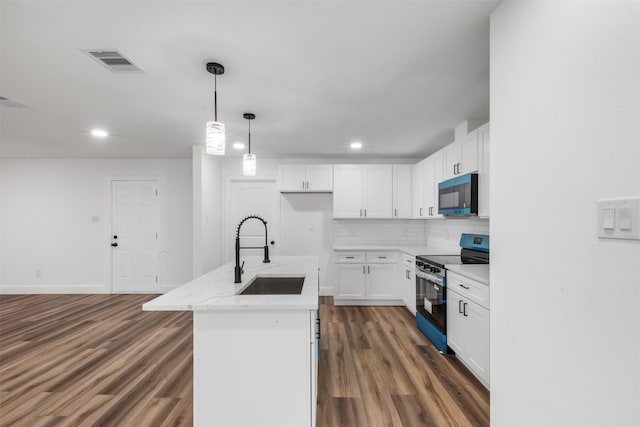 6155 Ridgeway Dr, Houston, TX 77033 - kitchen with electric range, black microwave, wood finished floors, white cabinets, and backsplash