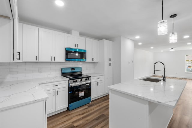 6155 Ridgeway Dr, Houston, TX 77033 - kitchen featuring stainless steel appliances, wood finished floors, recessed lighting, decorative backsplash, and white cabinets