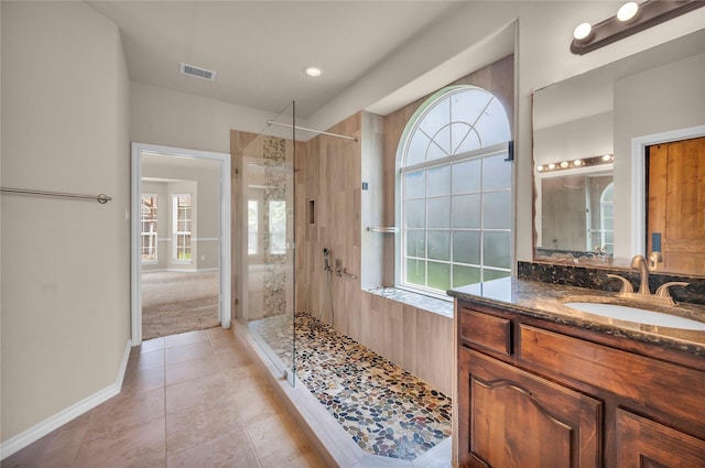 25402 Lancaster Pine Dr, Spring, TX 77389 - bathroom featuring tiled shower, plenty of natural light, tile patterned floors, and vanity