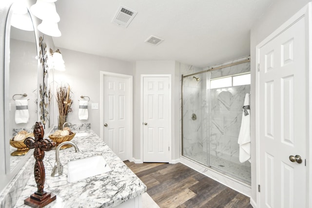 15723 Cascade Point Dr, Houston, TX 77084 - full bathroom featuring double vanity, a marble finish shower, wood finished floors, and baseboards