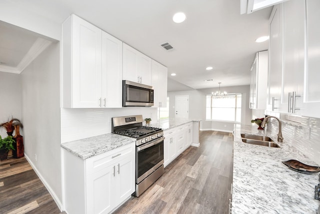 15723 Cascade Point Dr, Houston, TX 77084 - kitchen with stainless steel appliances, a sink, baseboards, white cabinetry, and recessed lighting