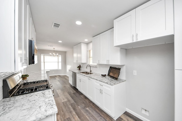 15723 Cascade Point Dr, Houston, TX 77084 - kitchen featuring appliances with stainless steel finishes, baseboards, decorative backsplash, a sink, and white cabinetry