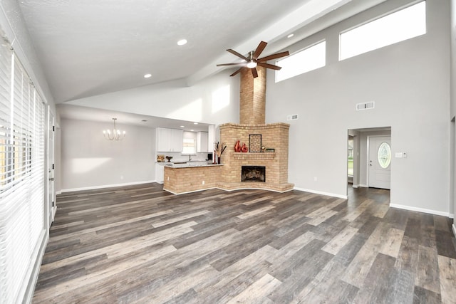 15723 Cascade Point Dr, Houston, TX 77084 - unfurnished living room featuring a ceiling fan, a chandelier, dark wood-style floors, plenty of natural light, and high vaulted ceiling